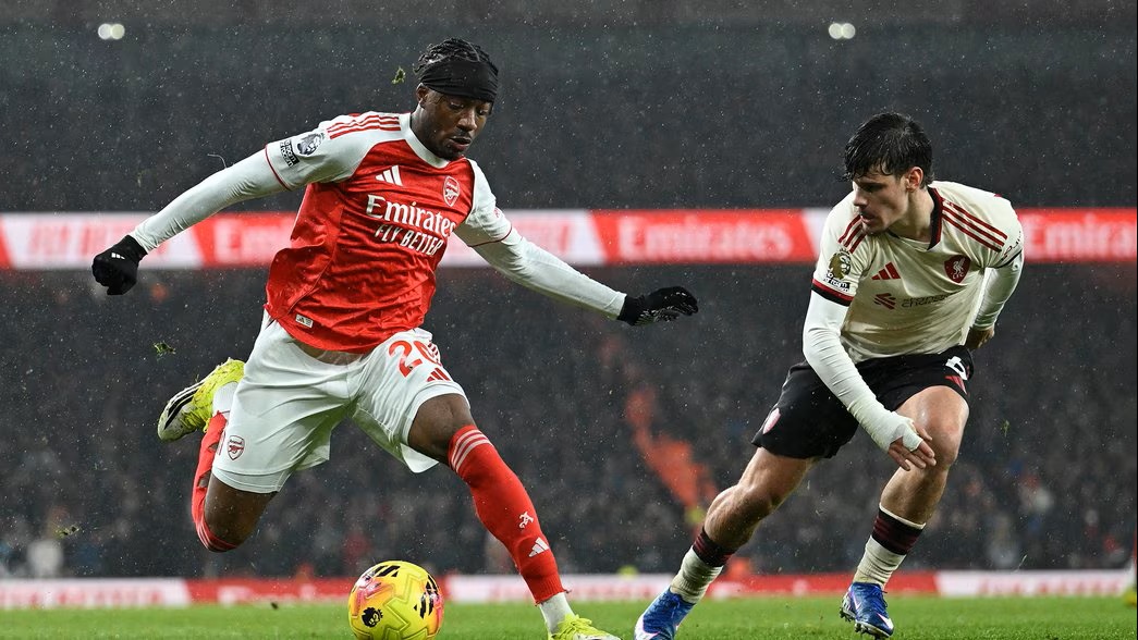 Arsenal and Liverpool players contest the ball during a tense Premier League match that ended in a draw, impacting the title race